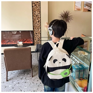 Close-up of children panda backpack featuring black white design and a green sport pouch