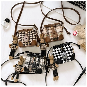 Flat lay of multiple tweed mini bucket bags with cute rabbit charms and metal lettering