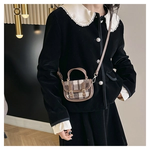 Détail d'un mini sac à main vintage à carreaux avec garniture en cuir et boucles dorées