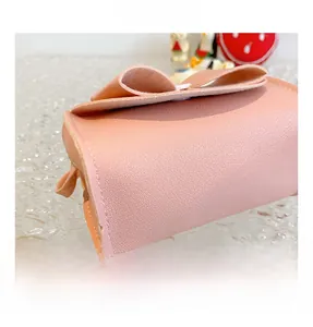 Detailed close-up showing the soft pink PU leather texture and large bow on the girl handbag