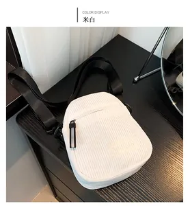 Détail d'un sac à bandoulière en velours côtelé blanc cassé avec sangle noire réglable