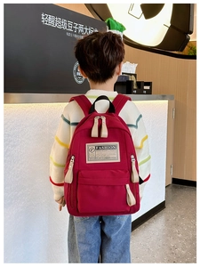 Détail d'un sac à dos rouge pour enfant en tissu nylon durable avec étiquette mode