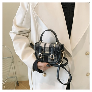 Détail d'un mini sac en tweed à carreaux avec lanières en cuir noir et boucle dorée