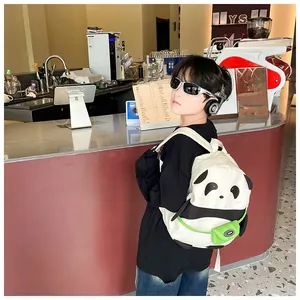 Side view of a boy wearing the cute panda backpack with 3D ears and green front pocket