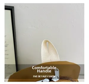 Detailed macro view of the brown fabric child backpack with durable off-white webbing handle