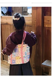 Rear view of child wearing a quilted floral tote bag with colorful patches and pink straps