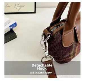 Dettaglio del gancio in metallo rimovibile e del cinturino in pelle sulla borsa in tweed