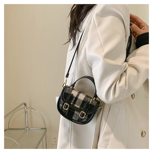 Détail du mini sac à main à carreaux avec motif noir et jaune et boucles dorées