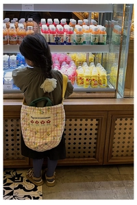Détail du sac bandoulière matelassé pour enfant avec sangle jaune réglable et broderie fine
