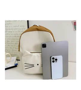 Size comparison of the cartoon cat canvas backpack with a tablet and smartphone
