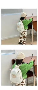 Detail showing a white sheep cartoon backpack on a child with plush ears and 3D details