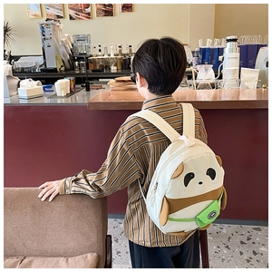 Detailed back view of a cute panda toddler backpack with adjustable straps in a cafe