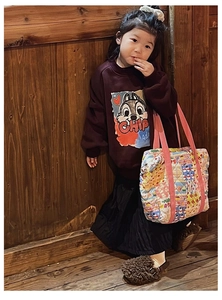 Detail showing kids quilted handbag with cartoon print and durable pink canvas handles