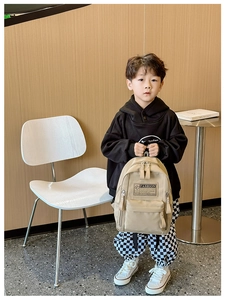 Vue détaillée du sac à dos enfant en toile kaki avec une poche avant zippée pratique