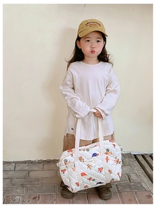 Close-up of white quilted floral handbag for girls with a matching cute yellow cap