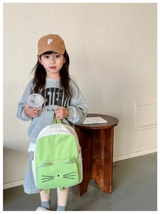 Toddler girl wearing light green cartoon cat backpack with 3D ears and canvas texture