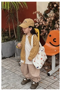 Outdoor shot of a girl wearing a white quilted crossbody bag with colorful graffiti patterns