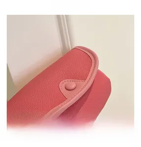 Detail of pink PU leather child bag showing lychee grain texture and snap closure