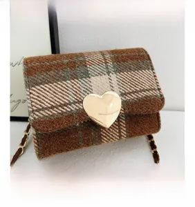 Detail of vintage plaid mini crossbody bag with heart-shaped metal lock and chain strap