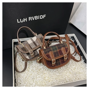 Détail de mini sacs à main en tweed à carreaux avec finitions cuir dans un coffret cadeau