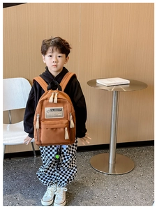 Gros plan d'un sac à dos enfant en toile marron avec poche zippée et étiquette Fashion