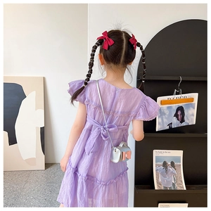 Detail of a purple ruffled girls' dress showing the back bow tie and flutter sleeves