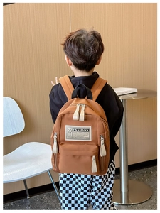 Vue arrière du sac à dos marron pour enfants avec bretelles et étiquette fashion