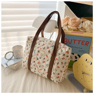 Detail of quilted cotton crossbody bag with floral and bear prints and brand label