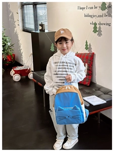 Close-up of sky blue and khaki patchwork kid's backpack with cute 3D cat ear details