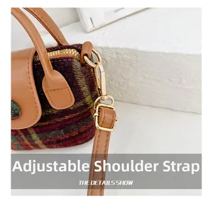 Close-up of adjustable leather shoulder strap and gold hardware on plaid handbag