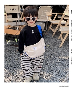 Kids off-white canvas crossbody bag with blue wide strap in an outdoor camping setting
