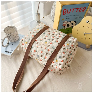 Detail of floral quilted girls crossbody bag with cute bear patterns and brown straps