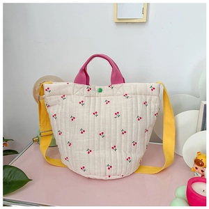 Détail du sac matelassé pour enfant avec motif cerise et bandoulière jaune réglable
