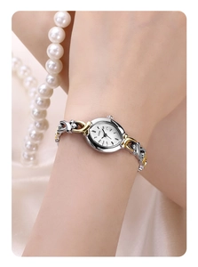 Detail of elegant two-tone gold and silver link strap on a small oval women's watch