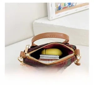 Internal compartment of the plaid mini bag showing storage space and metal zipper