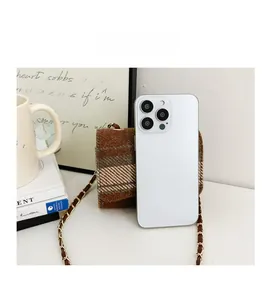 Brown plaid crossbody bag size comparison with a smartphone in a lifestyle setting