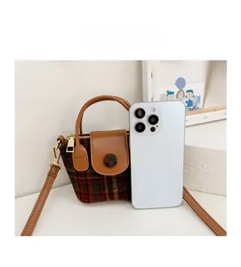 Miniature plaid handbag shown next to a smartphone for precise size comparison