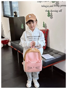 Detail of pink and tan cartoon cat backpack with 3D ears and embroidery for kids