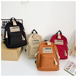 Détail d'une collection de sacs à dos en toile minimalistes noir beige orange et rouge