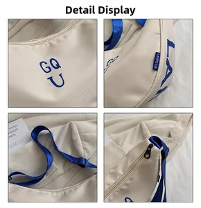 Detail view of cream canvas crossbody bag with blue GQ U print and adjustable strap