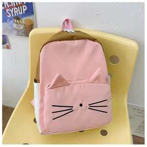 Detail of cute cat-themed pink backpack with embroidered whiskers on modern yellow chair