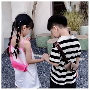 Kids PU leather mini crossbody bag with adjustable straps for girls and boys in outdoor setting