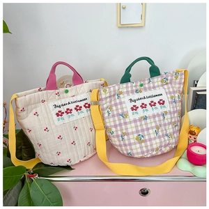 Détail de sacs fourre-tout pour enfants à fleurs et carreaux avec bandoulières jaunes