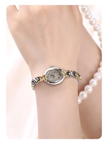 Close-up of GEDI ladies watch with gold and silver woven strap and oval dial
