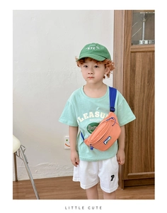 Close-up of orange waterproof nylon kids waist bag paired with a green street style outfit