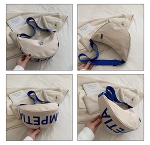 Detail view of canvas smiley bag with adjustable strap and side lettering accents