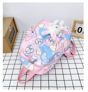 Dettaglio zaino per bambini sfumato rosa con stampe di conigli e ciondolo di peluche