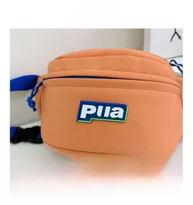 Detailed close-up of orange canvas kids waist bag with Pila logo and adjustable blue strap