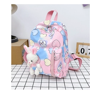 Dettaglio zaino da bambina sfumato rosa con stampe di cuori e ciondolo a forma di coniglio