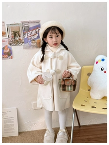 Close-up of creamy white hooded plush jacket with soft pom-poms and large side pockets